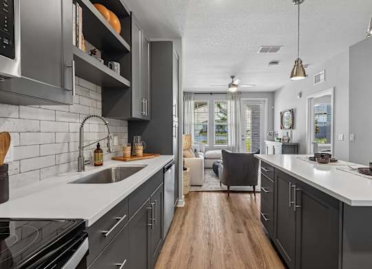A modern kitchen with a white countertop and dark cabinets.