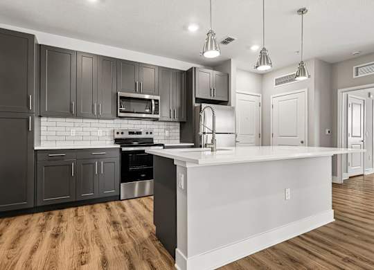 A modern kitchen with dark wood cabinets and a white island.