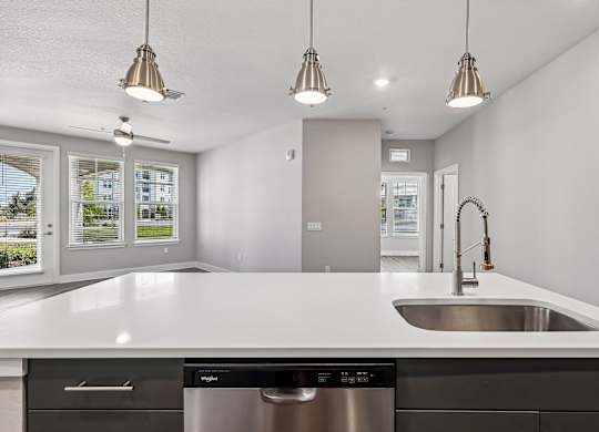 A modern kitchen with a stainless steel dishwasher and a white countertop.