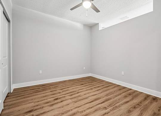 A room with a wooden floor and a ceiling fan.
