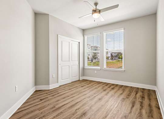 A room with a wooden floor and a ceiling fan.