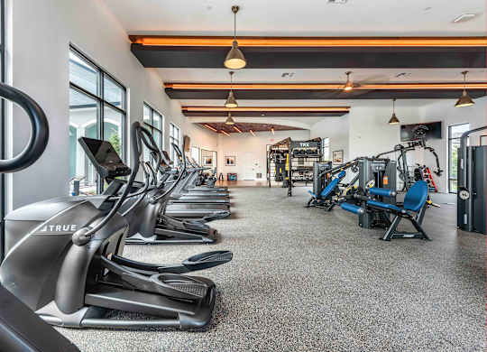 A gym with treadmills, elliptical machines, and other exercise equipment.