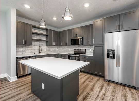 A modern kitchen with a white island and stainless steel appliances.