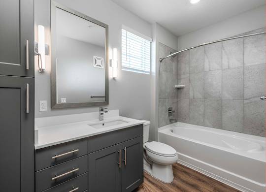 A modern bathroom with a white sink and a bathtub.