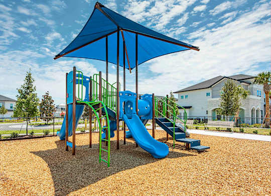 A playground with a blue canopy and a green slide.