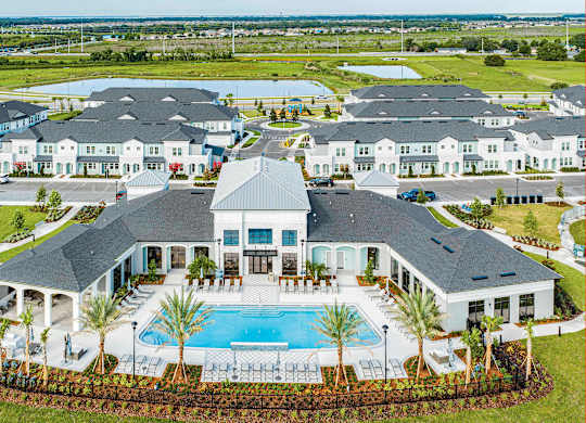 A large house with a pool in front.
