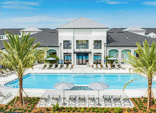 A large white building with a pool in front.