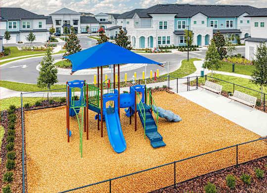 A playground with a blue umbrella and a yellow slide.