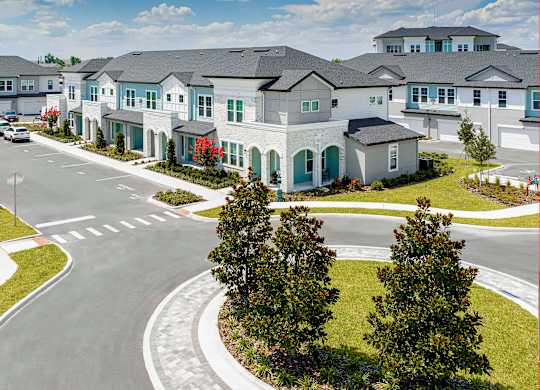 A street view of residential area with townhouses and trees.