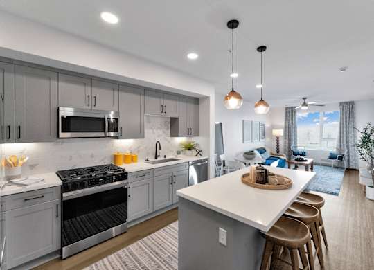 A modern kitchen with a large island and stainless steel appliances.