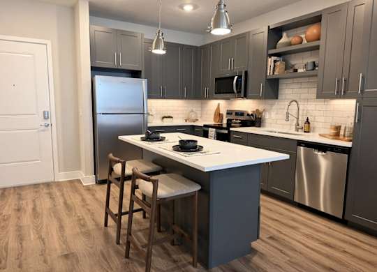A kitchen with a white countertop and a stainless steel refrigerator.