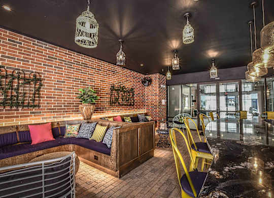 A cozy indoor seating area with a brick wall and hanging light fixtures.
