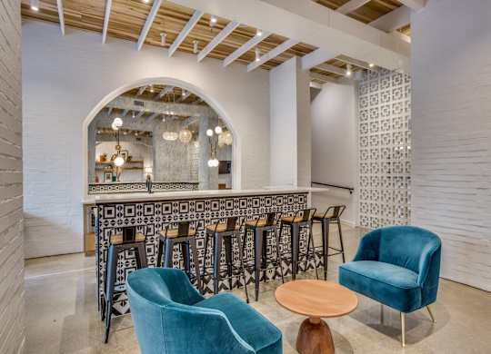A room with a bar and chairs.