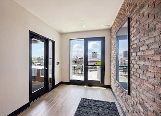 A room with a brick wall and a black door.