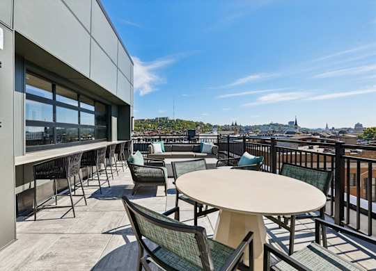 A patio with a table and chairs overlooking a city.