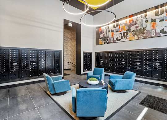 A modern office space with blue chairs and a large artwork on the wall.