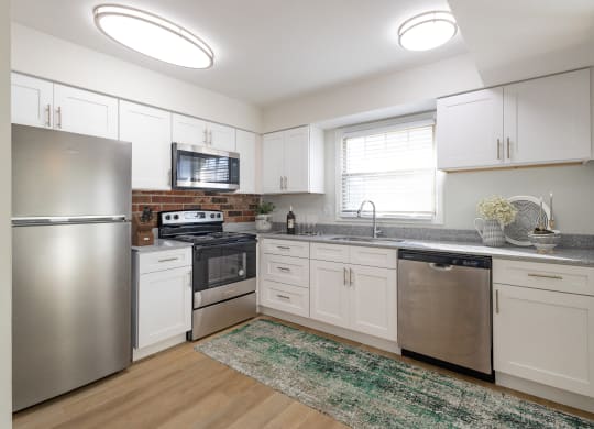 a kitchen with stainless steel appliances and white cabinets