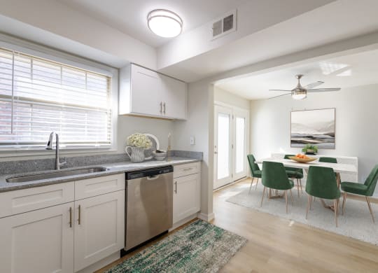 a kitchen and dining room with white cabinets and a table and chairs