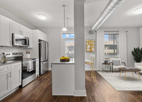 A modern kitchen with white cabinets and stainless steel appliances at CityWay Apartments, Indiana