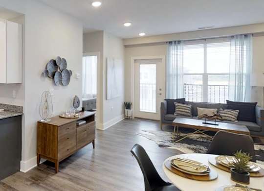 an open kitchen and living room with a table and chairs at Echo Park at Perry Crossing Apartments, Indiana