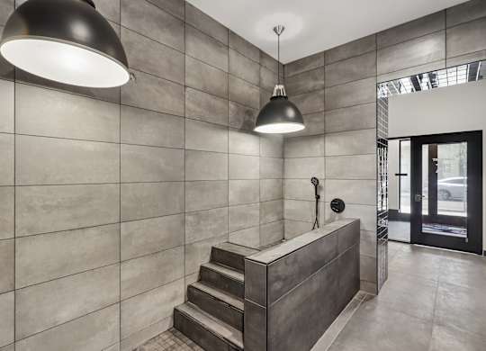A modern bathroom with a concrete wall and a concrete staircase.