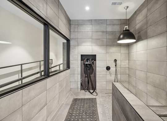 A modern bathroom with a walk-in shower and a window.