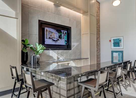 a long bar with chairs and a tv on the wall