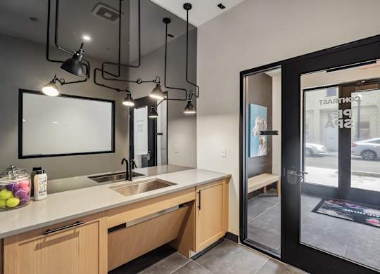 A modern kitchen with a sink, countertop, and a view of the street outside.