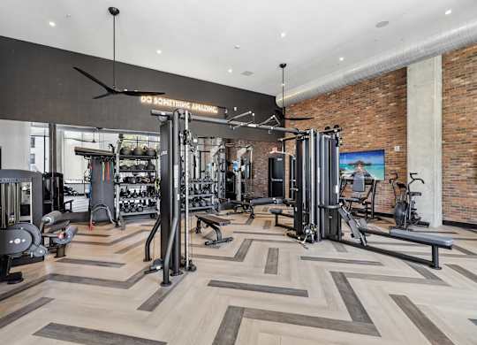A gym with a variety of equipment including a squat rack, bench, and weights.