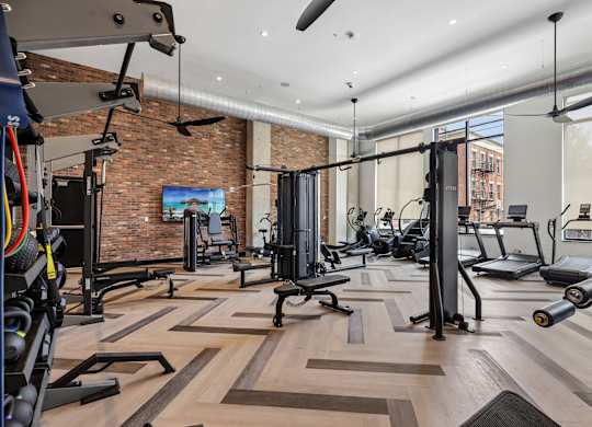 A gym with a brick wall and wooden floors.