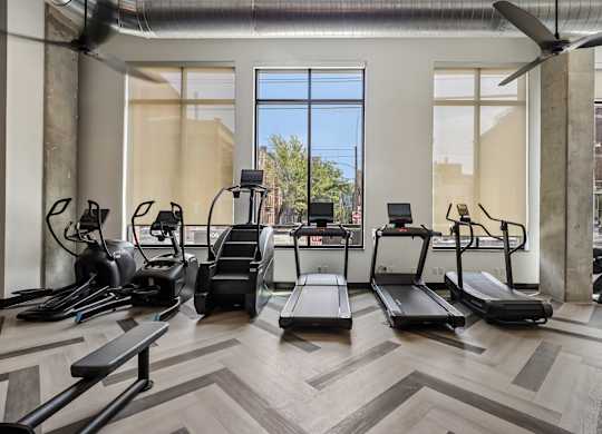 A gym with treadmills, elliptical machines, and other exercise equipment.