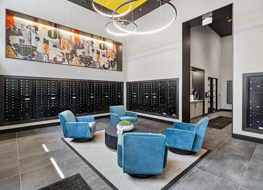 A modern waiting area with blue chairs and a large artwork on the wall.