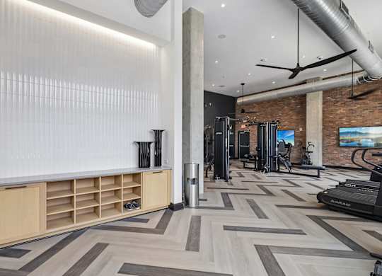 A gym with a variety of equipment including treadmills and weights.