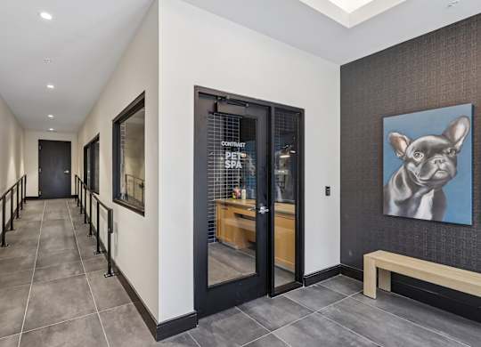A hallway with a bench and a painting of a dog on the wall.