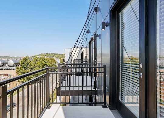 Private balcony at Contrast OTR apartments in Cincinnati, OH with sleek glass doors and city views.