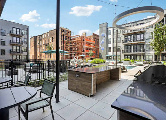 A patio with a table and chairs overlooks a city street.