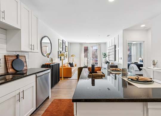 A modern kitchen with a black countertop and white cabinets.