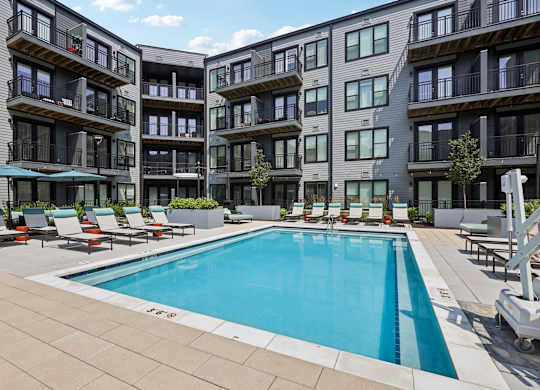 A swimming pool in front of apartment buildings.