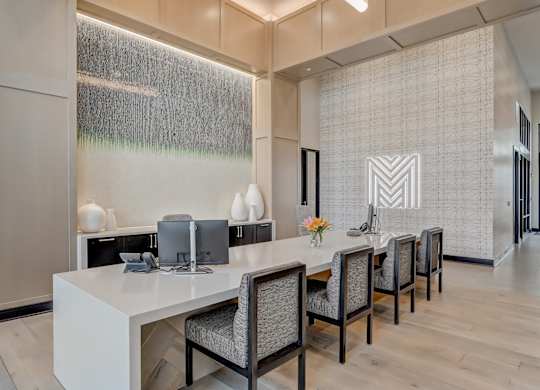 a modern office with a long desk and chairs