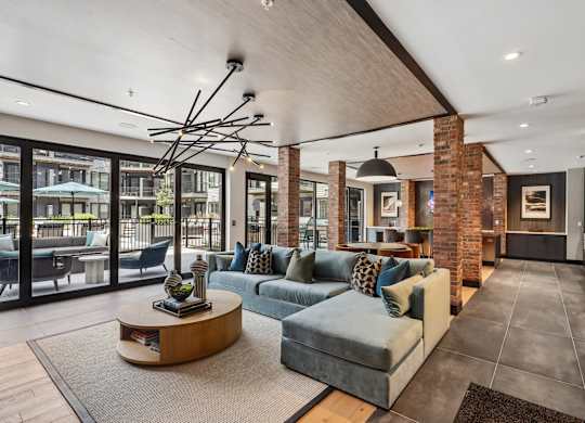 A modern living room with a large grey sofa and a coffee table.