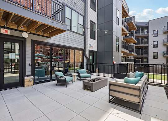 A patio area with a couch, chairs, and a coffee table.