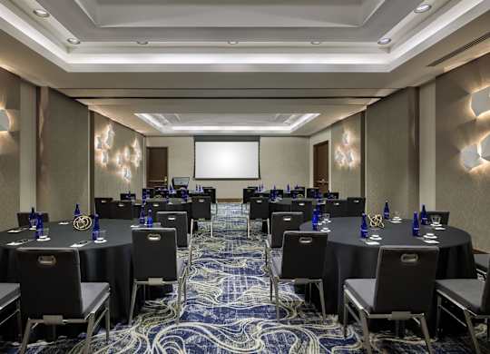A conference room with black tables and chairs.