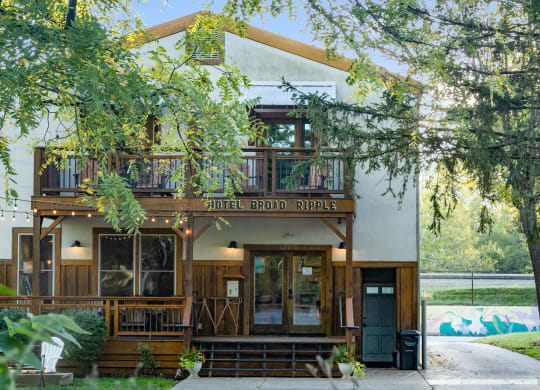 the front facade of a building with trees and a sidewalk