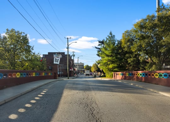 a city street with a fence and trees on the side of the road