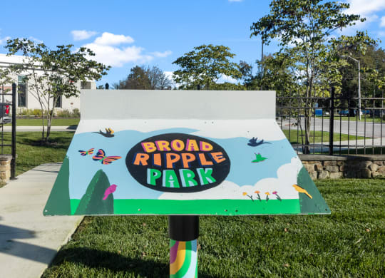 a sign that says broad ripple park in front of a sidewalk
