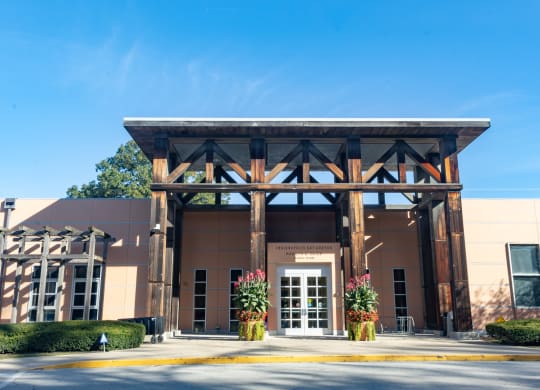 the front entrance of a building with a brown facade and pillars