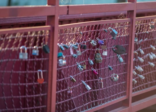 a red fence with a bunch of padlocks on it