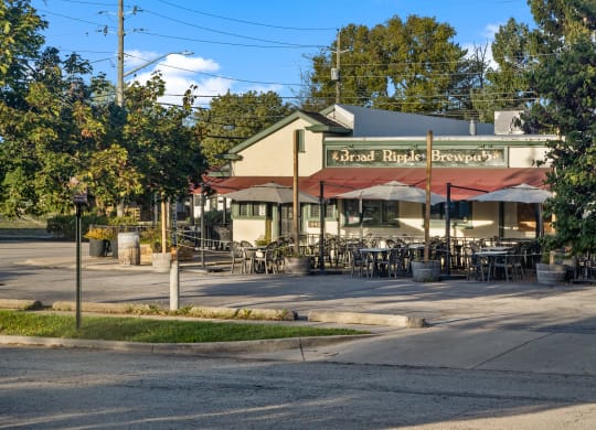 the outside of a restaurant with tables and umbrellas