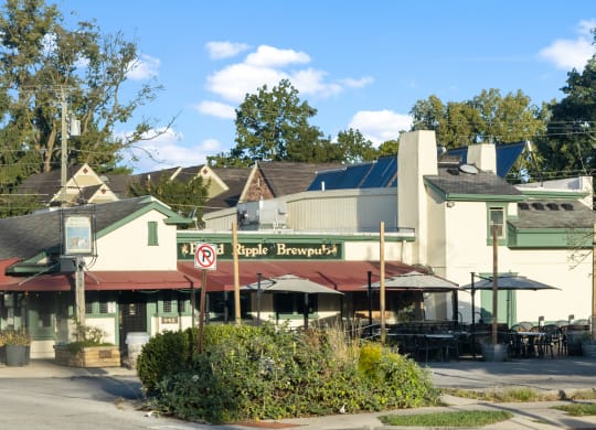 a restaurant with tables and umbrellas in front of a building