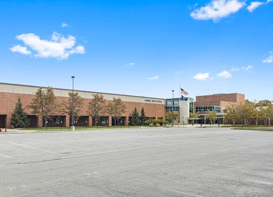 an empty parking lot in front of a building with an flag